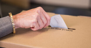Une électrice dépose son bulletin de vote dans l'urne.