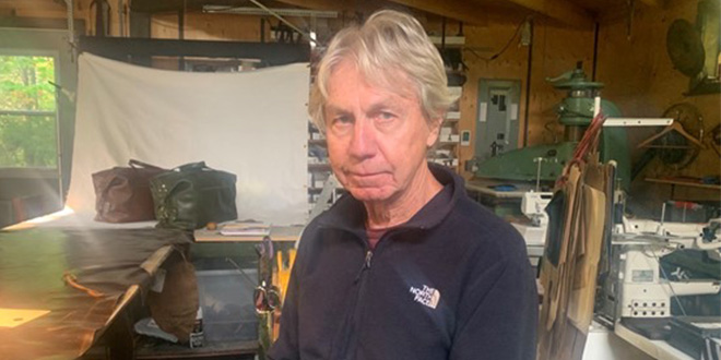 Le couturier et fondateur de Studio Instinct, Pierre Beaudoin, assis dans son atelier au Saguenay. Photo par Lauriane Boudreau.