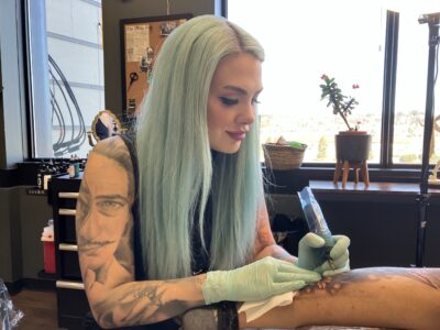 Gabrielle Munger, la tatoueuse, est en train de tatouer la jambe d'une personne.