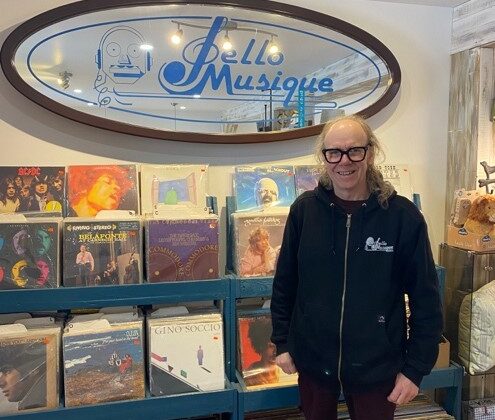 Le propriétaire Angelo Villeneuve devant l'enseigne de son commerce