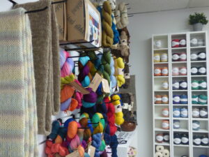 Pelotes de laines colorées accrochées dans l'atelier-boutique l'Attirail.